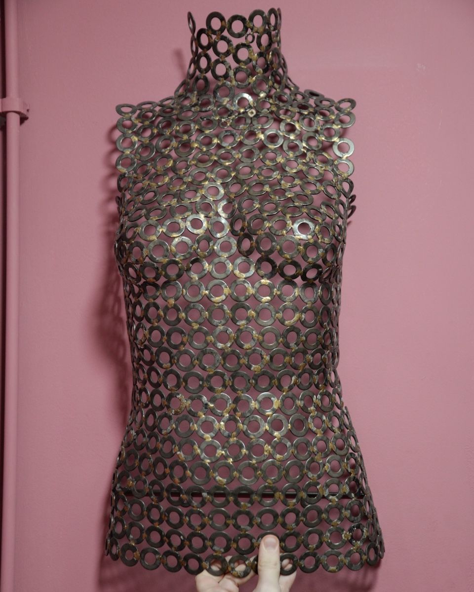 "Vesta" Female Torso Reclaimed Metal Wall Sculpture mounted on wall with hand in shot for scale