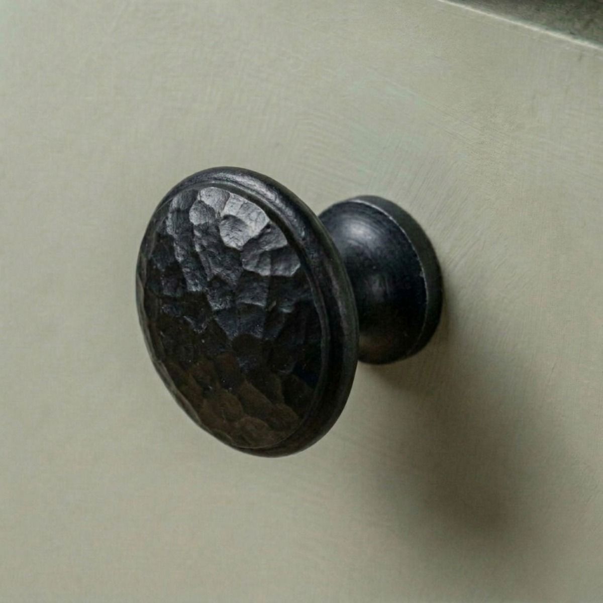 A 30mm Hammered Beeswax Cabinet Knob Mounted on a Green Contemporary Kitchen Cupboard - Digital Illustration 