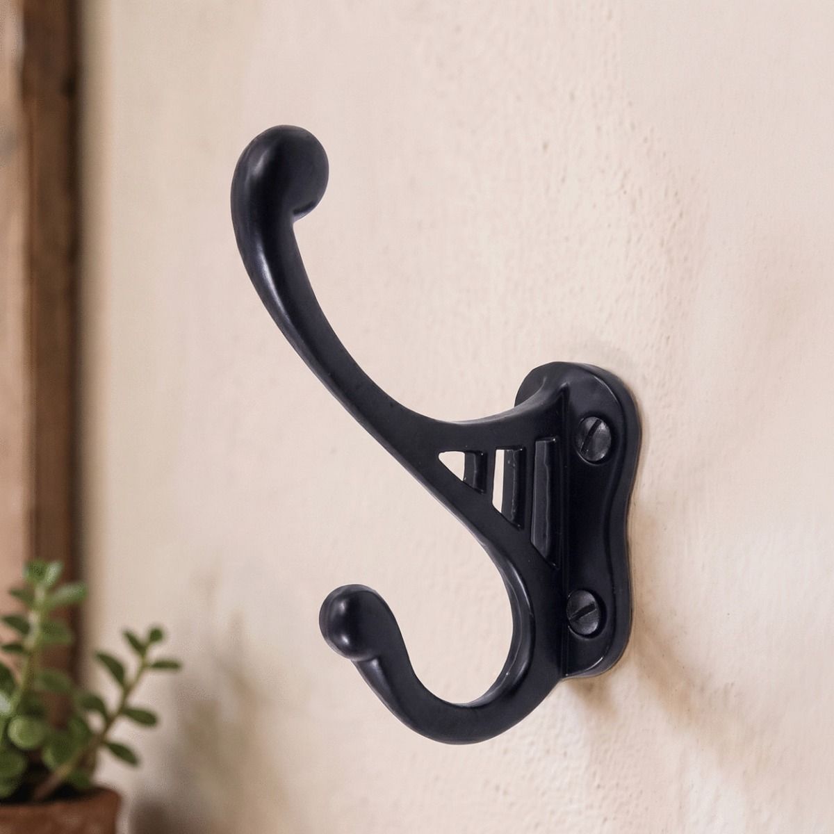 A Black Bayswater Iron Coat Hook Polished Mounted on a Textured Hallway Wall - Digital Illustration 