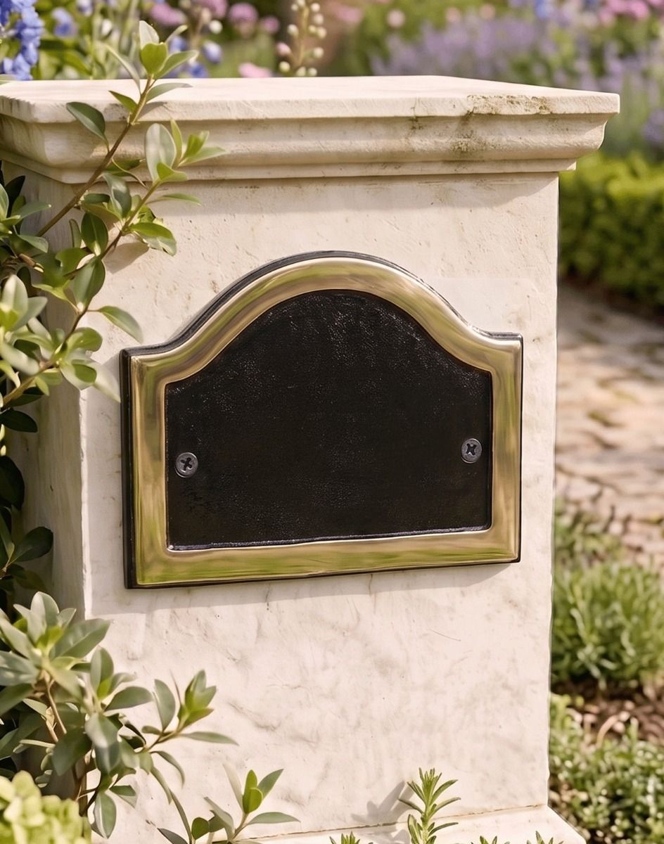 A Blank Arched House Number Plaque in a Black and Brass Finish Mounted on a Cream Coloured Driveway Entrance Pillar - Digital Illustration 