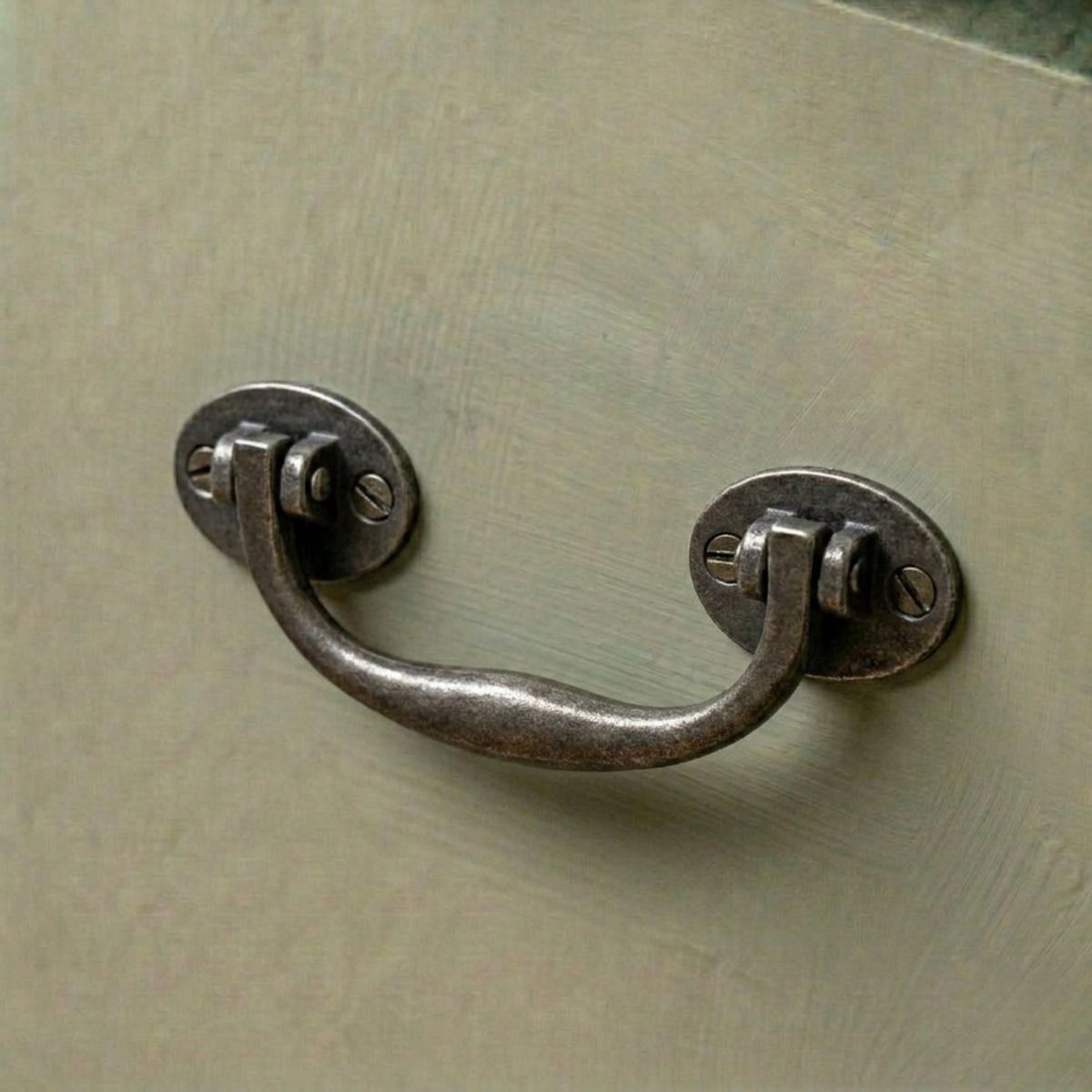 A Bronze Cabinet Pull Handle Mounted on a Sage Green Kitchen Cabinet Drawer - Digital Illustration