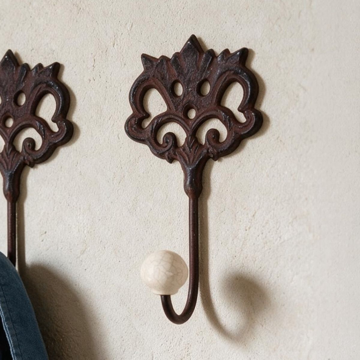 A Close up of "Lady Elinor" Cast Iron Hook Pictured on a Sunny Interior Wall - Digital Illustration 