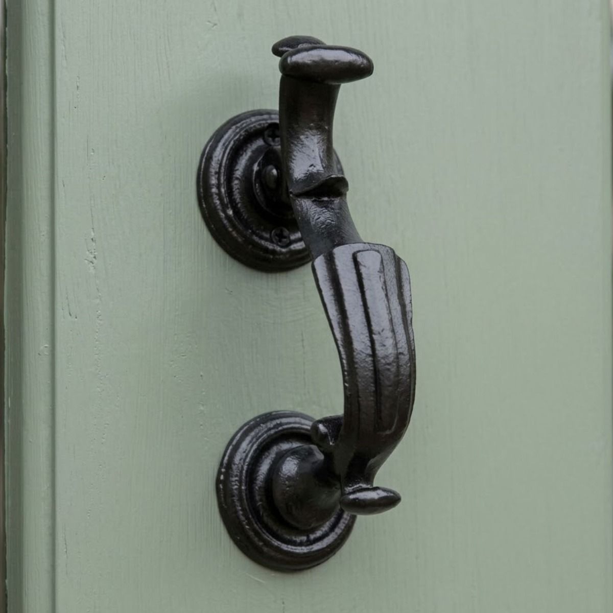 A Close up of the "Belgrave Manor" Cast Iron Victorian Door Knocker on a Sage Green Door - Digital Illustration