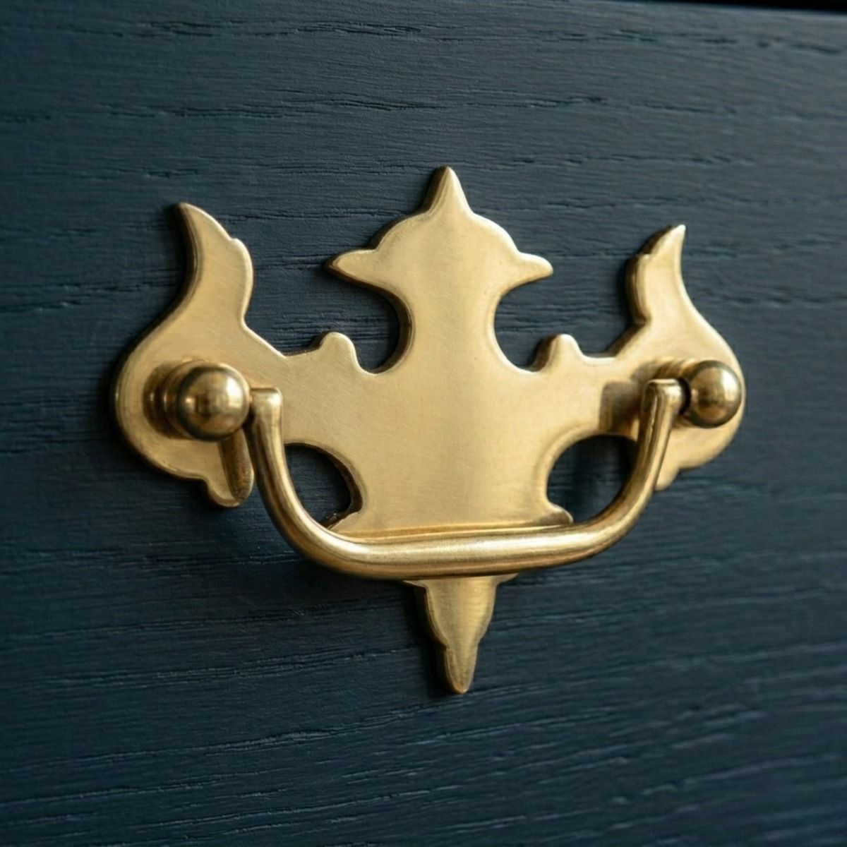 A Fleur de Lys Design Polished Brass Cabinet Handle Mounted on a Royal Blue Kitchen Cabinet - Digital Illustration