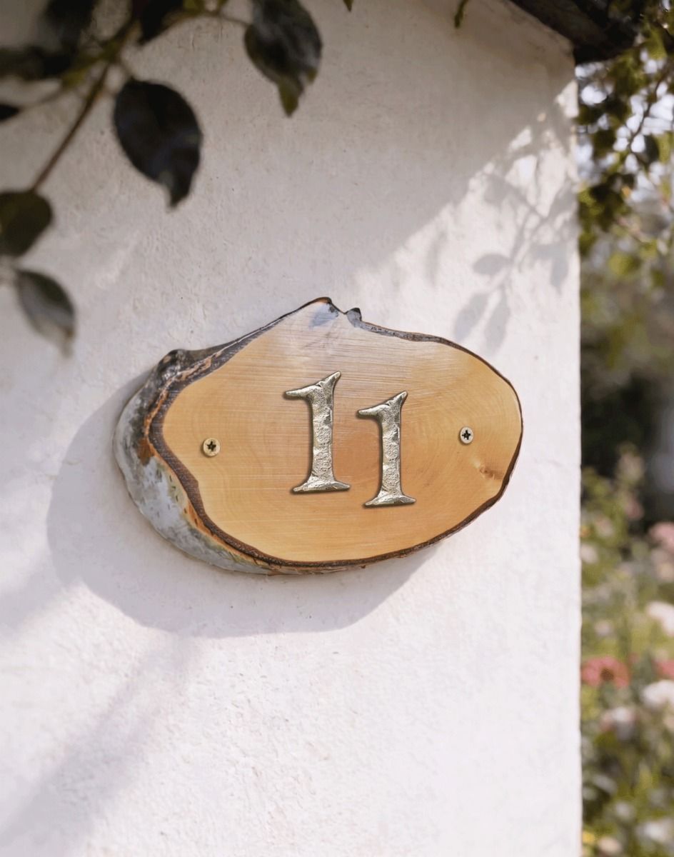 A Number 11 Natural Hard Wood Rustic House Number Sign Mounted on a Sunny White Cottage Wall - Digital Illustration 