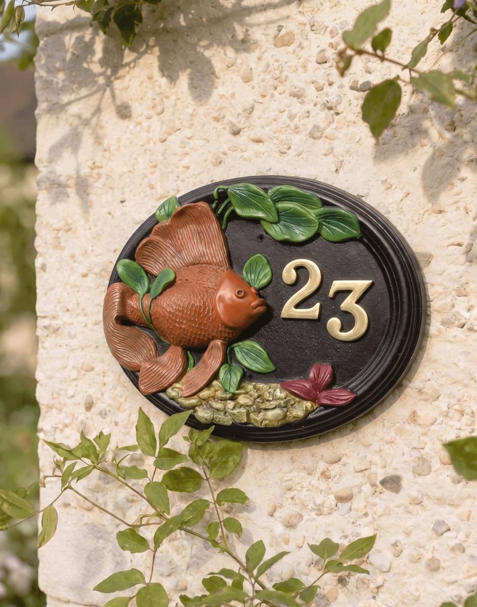 A Number 23 "Wellhurst Lakes" Hand Painted Goldfish House Sign Mounted on a sunny Cottage Garden Wall - Digital Illustration