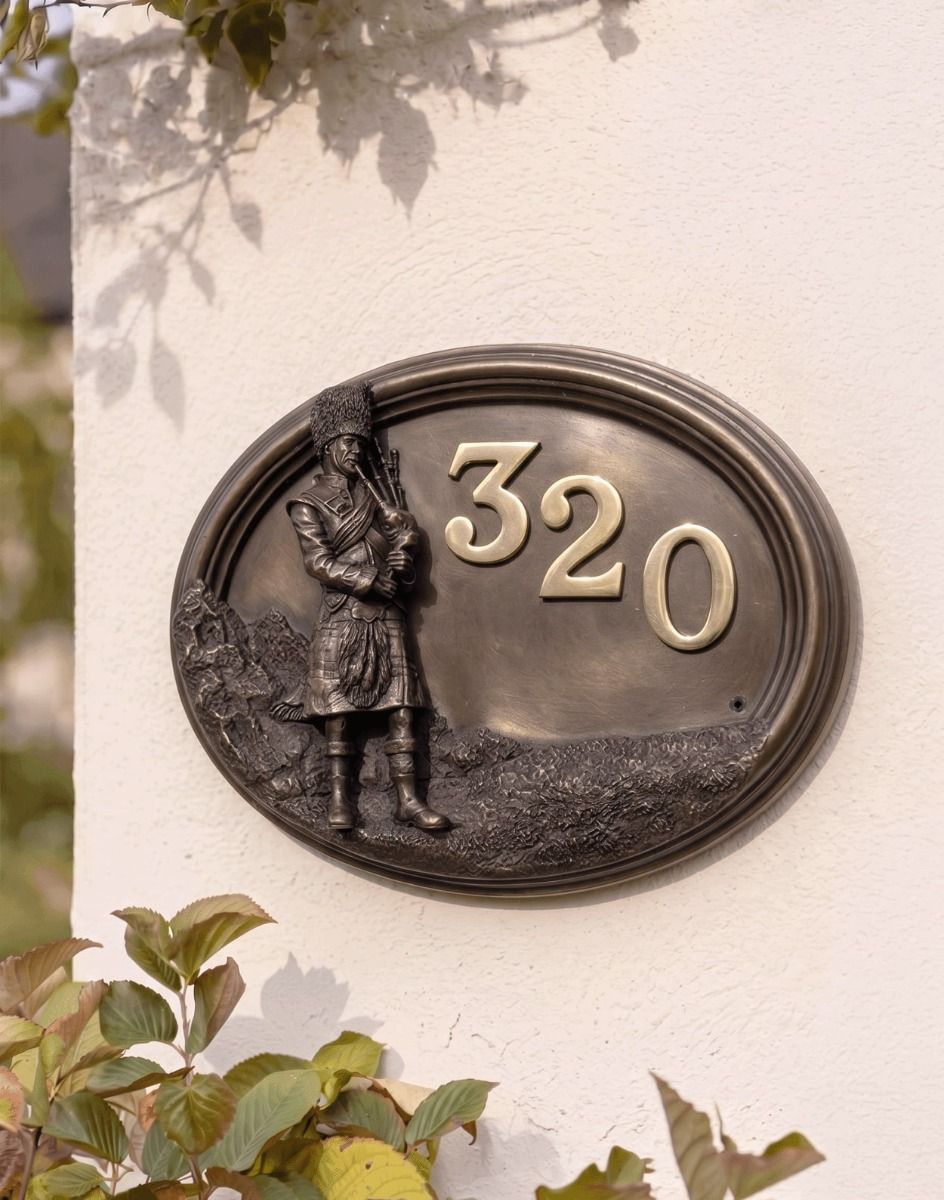 A Number 320 "Scottish Highlander" Bronze House Sign Mounted on a White Coloured Cottage Garden Wall - Digital Illustration 