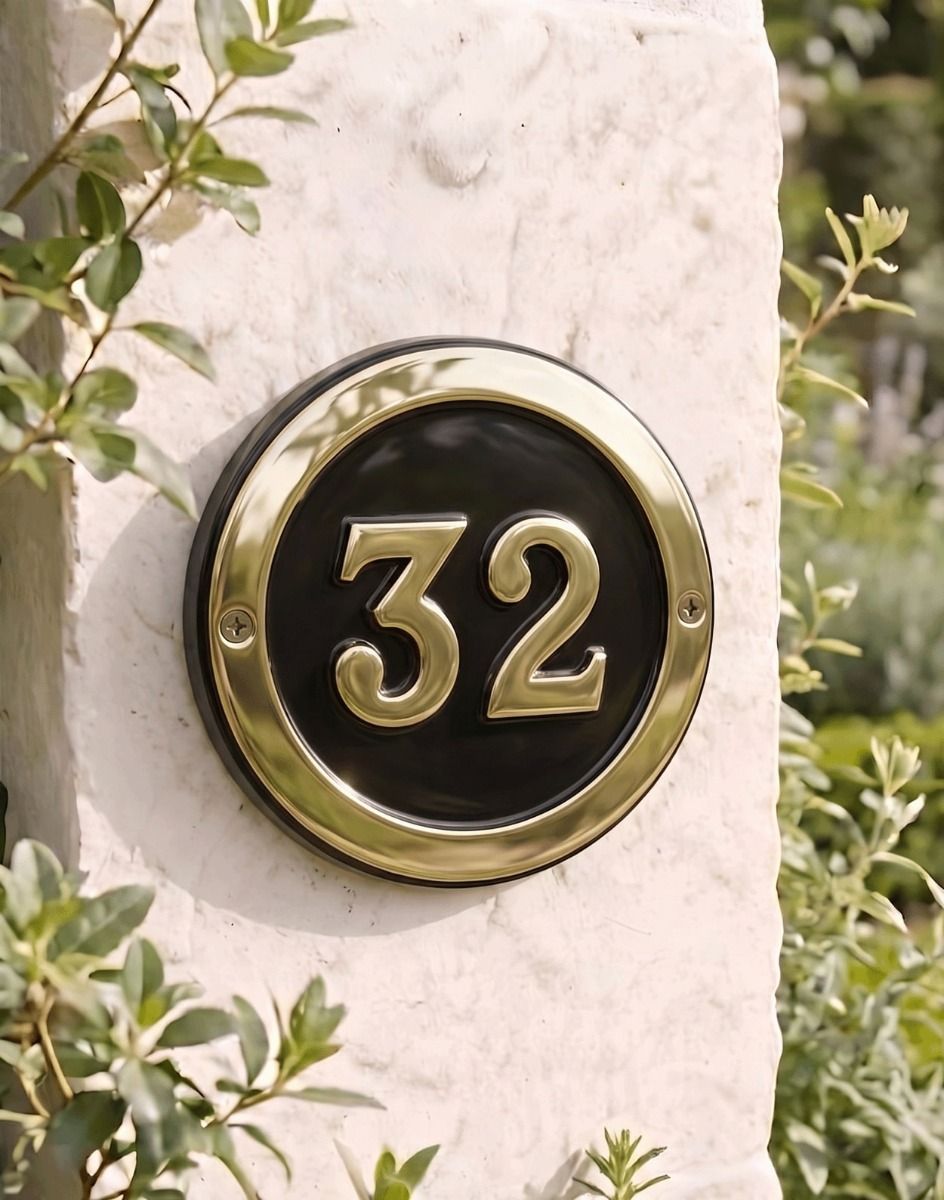 A Number 32 Round Brass & Black House Number Sign Mounted on a Textured Cottage Wall - Digital Illustration