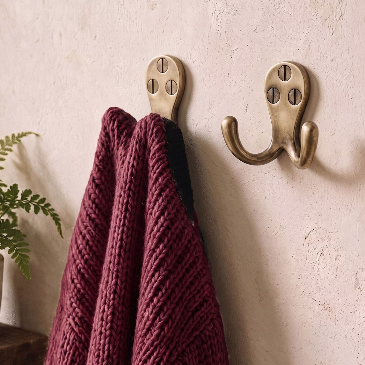 The Aged Brass Double Pronged Coat Hook on a Cream Coloured Interior Wall - Digital Illustration 
