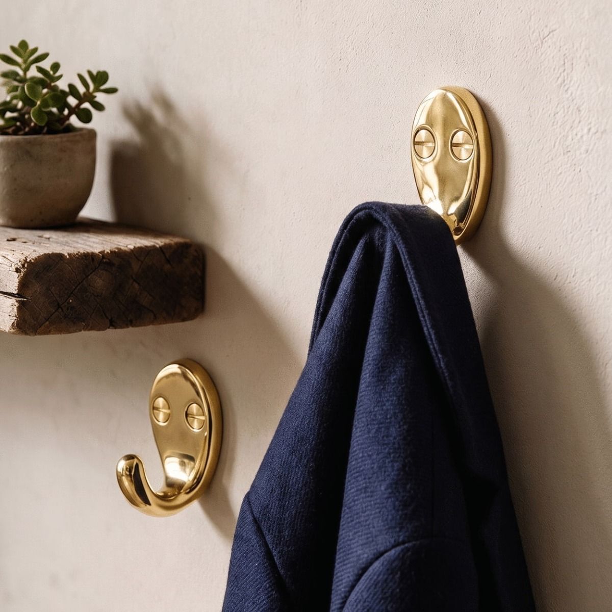 A Pair of Polished Brass Single Pronged Coat Hooks Fitted in a n Entrance Hallway with One Hook Holding a Coat - Digital Illustration 