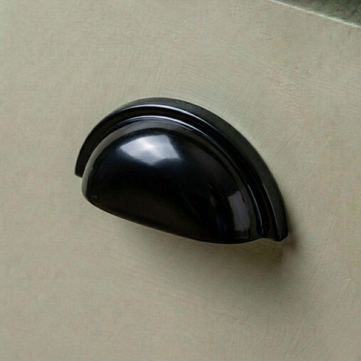 A Sleek Black Concealed Drawer Pull Mounted on a Sage Green Kitchen Drawer - Digital Illustration 