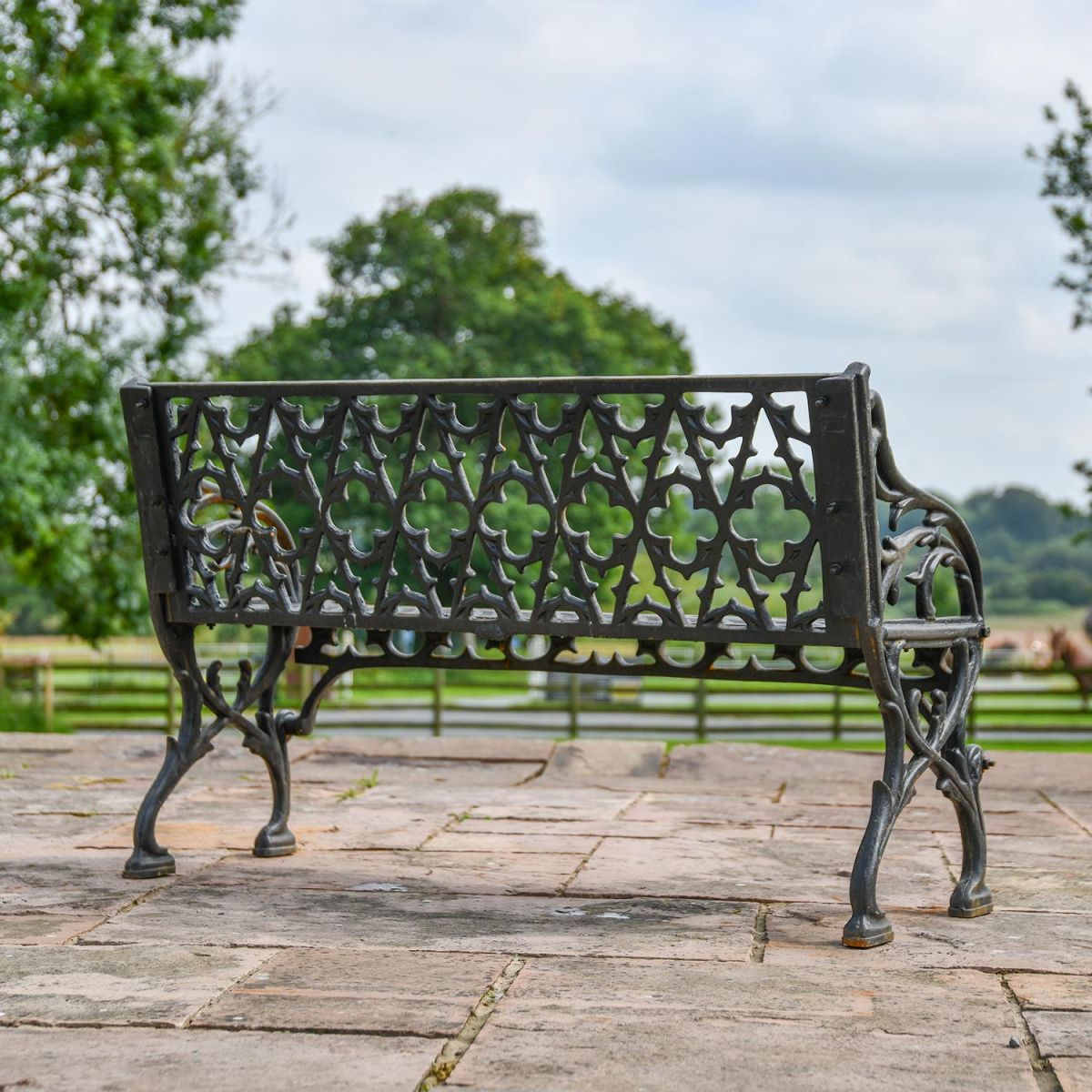 View of the Back of the Aged Black "Quatrefoil" Victorian Cast Iron Two Seat Bench View of the Back of the Aged Black "Quatrefoil" Victorian Cast Iron Two Seat Bench