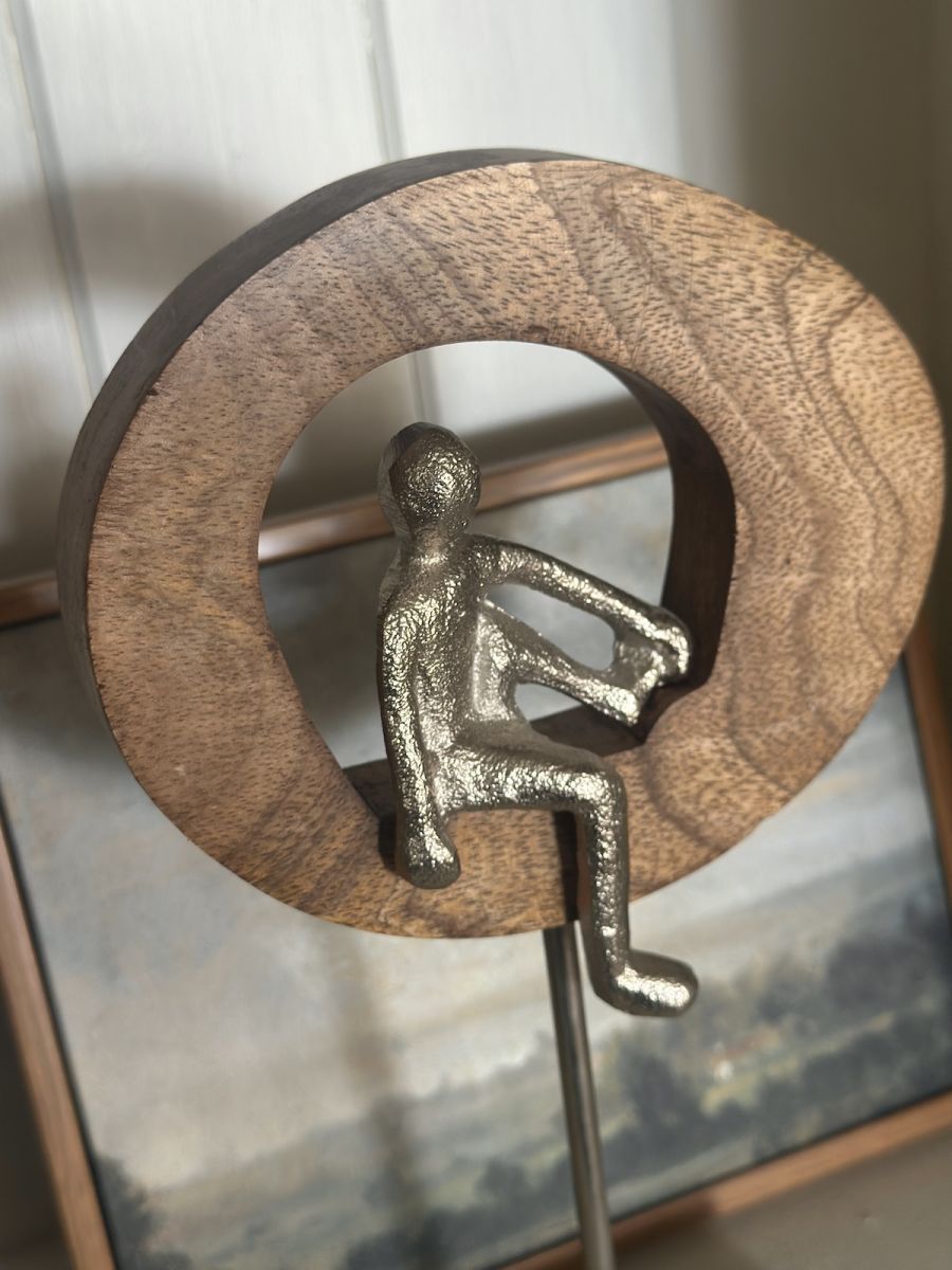 Angled close up of silver figure on home decor ornament