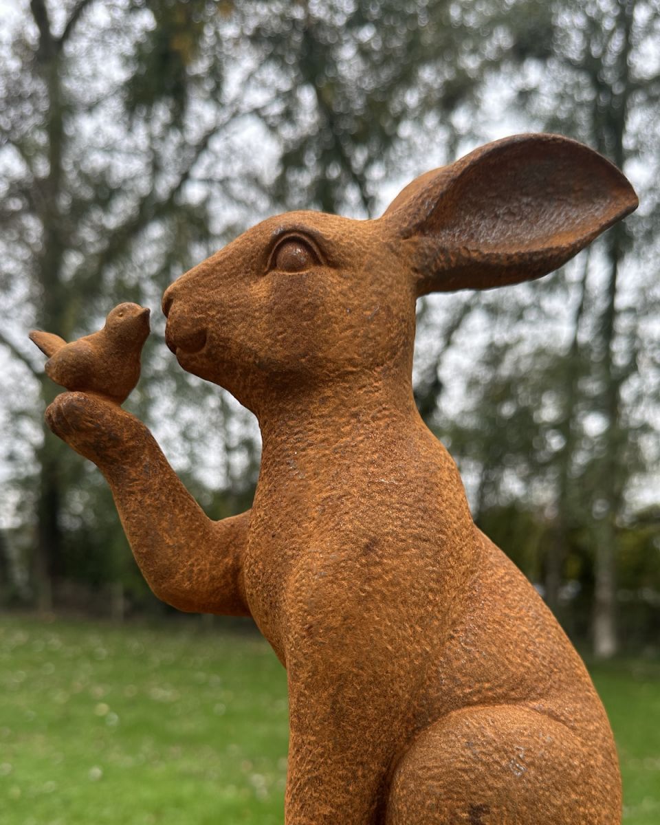Angled close up of rabbit and bird rustic finish garden sculpture