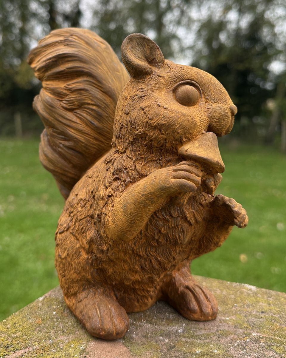 Side view of rustic finish squirrel with mushrooms garden sculpture