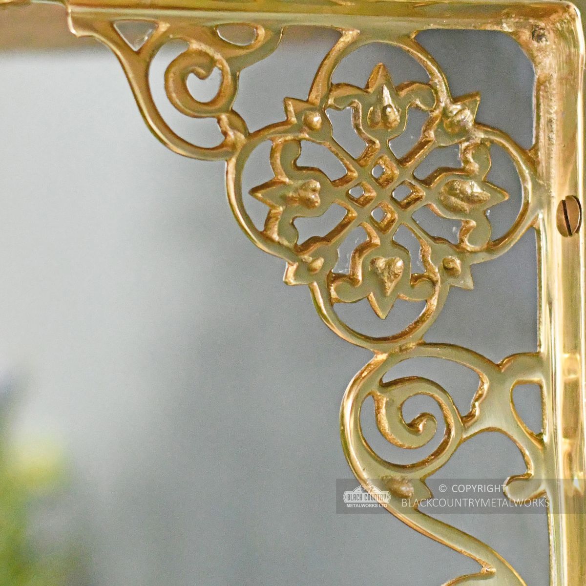 Detailed image of brass ornate shelf bracket
