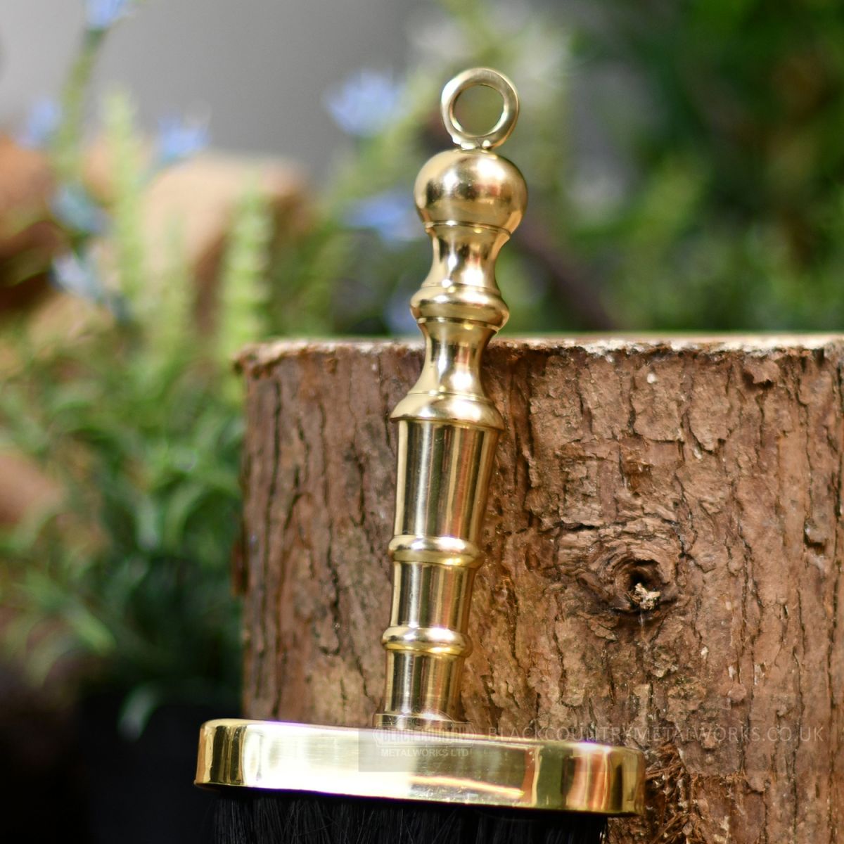 Detailed image of polished brass handle on brush