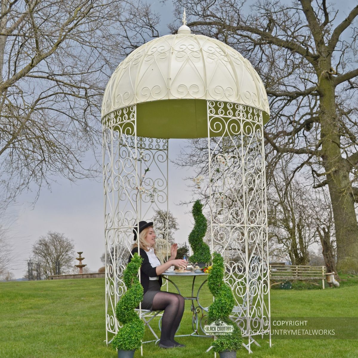 Ornate tradtional gazebo in garden with solid roof