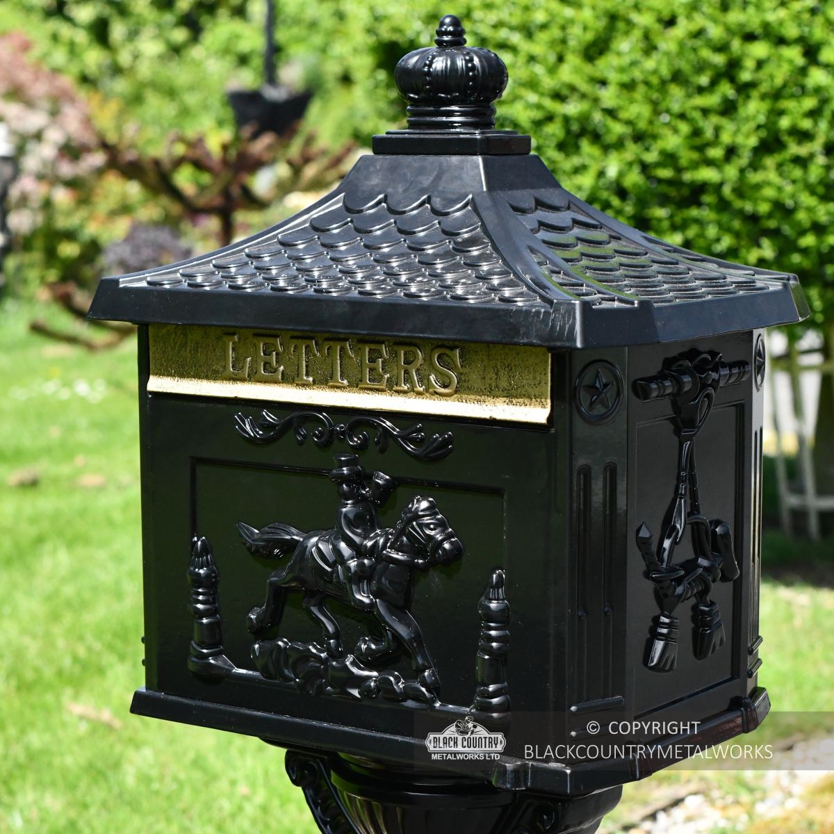 Black ornate secure post box with brushed gold letter flap