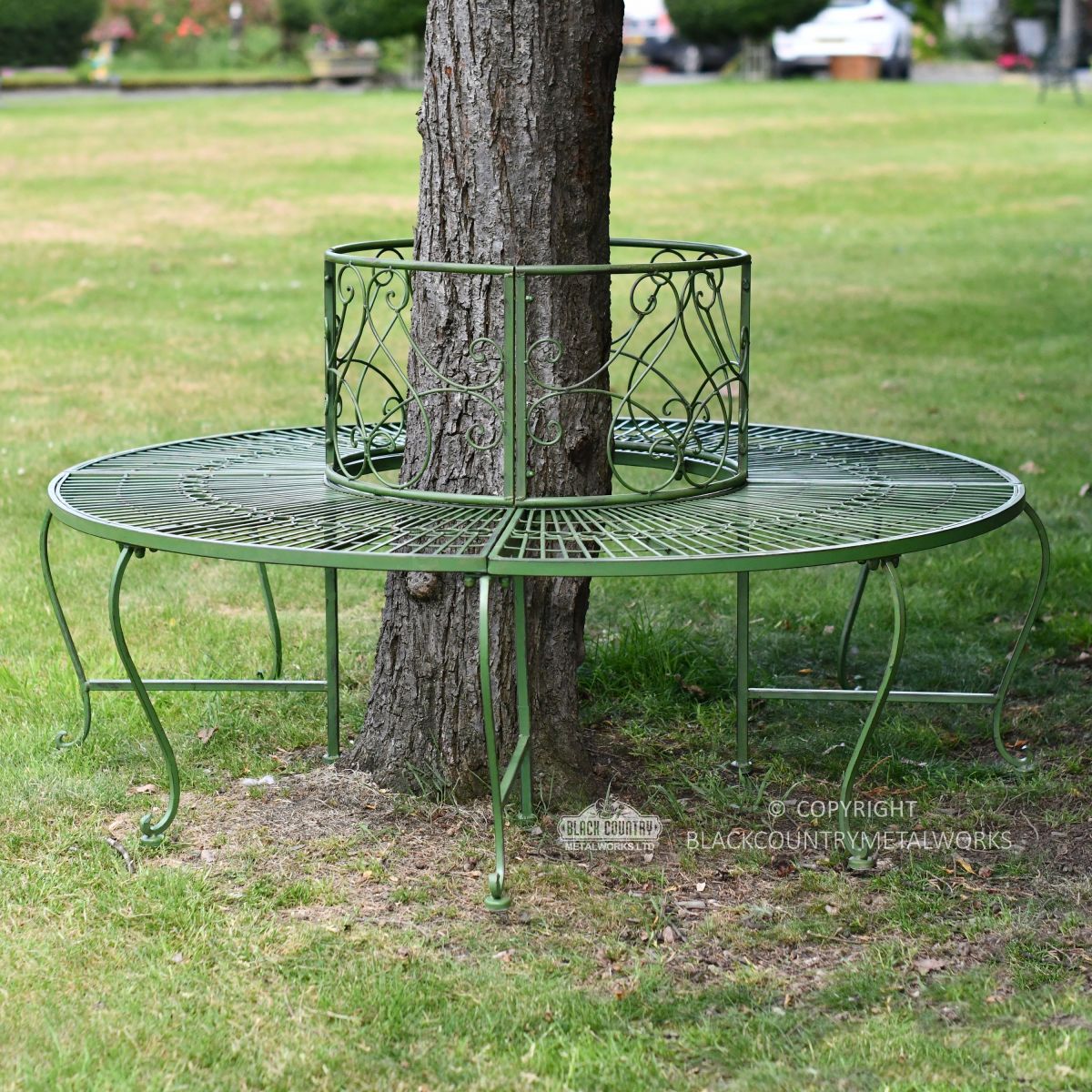 Green metal tree seat in landscaped garden
