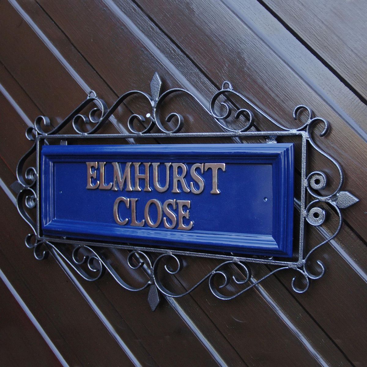 Blue "Belgravia" Ornate Wrought Iron Scrolled Sign on a Wooden Wall