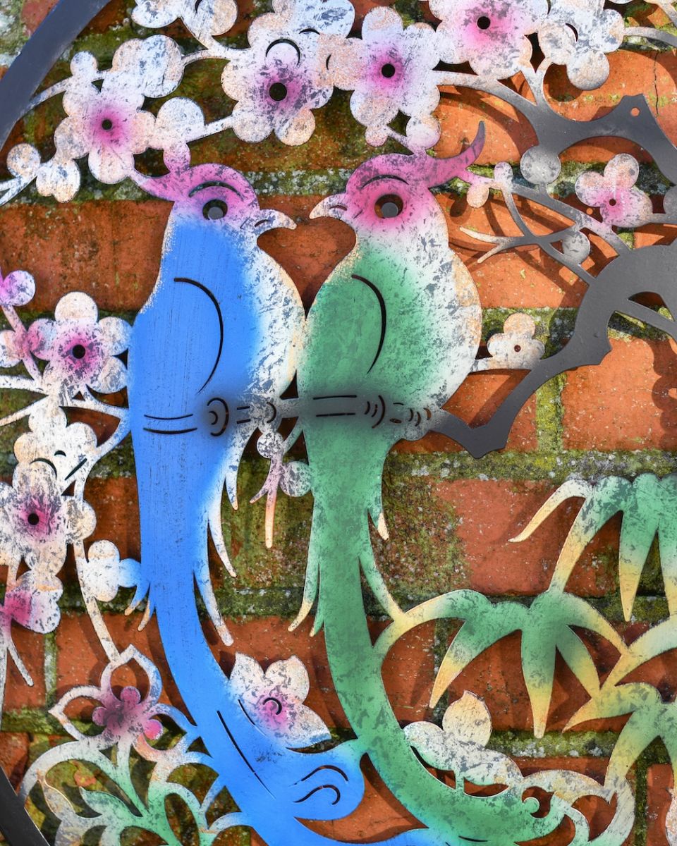 Close up of bird detail on colourful garden wall art