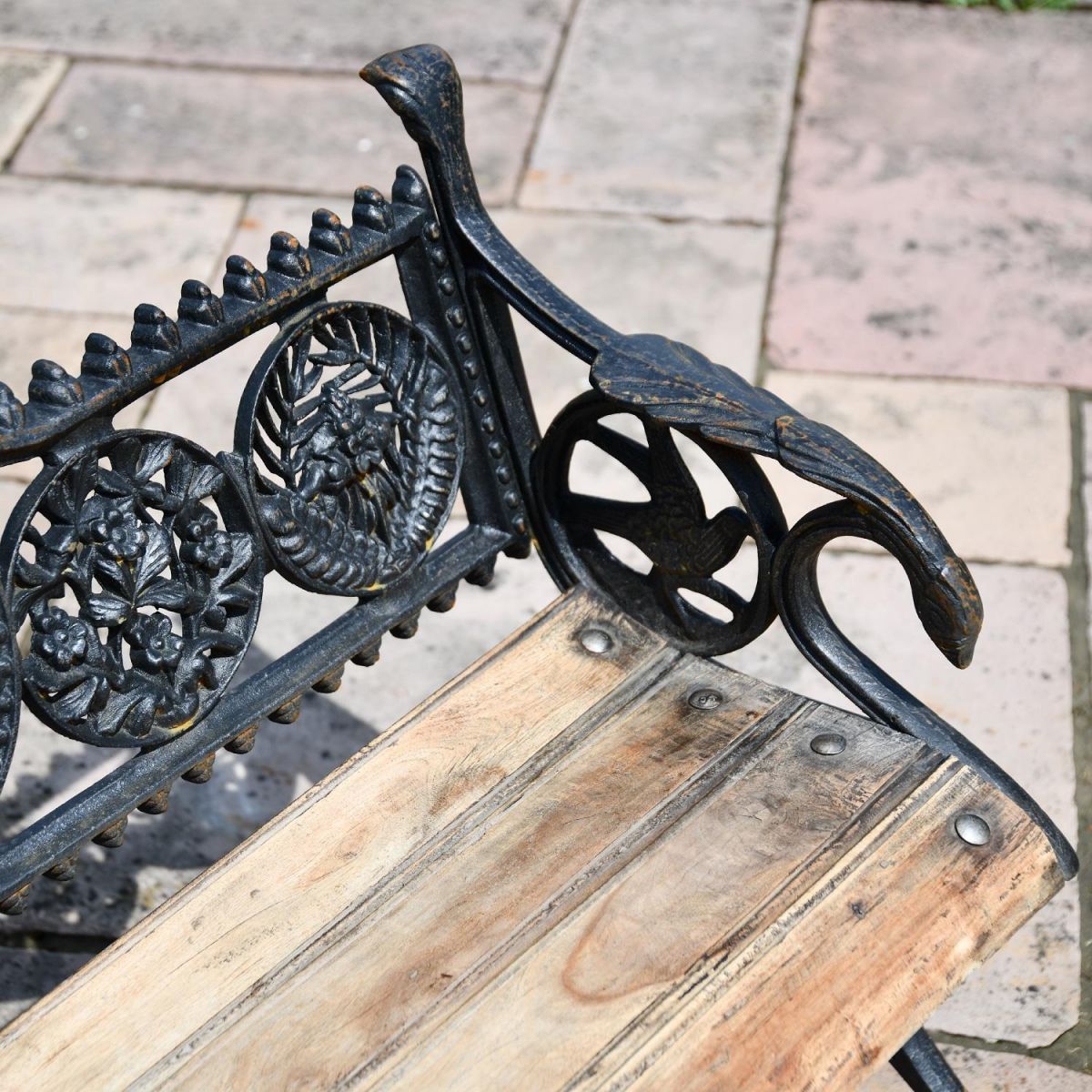 Close up of view of Aged Black Cast Iron Bench with wooden slats