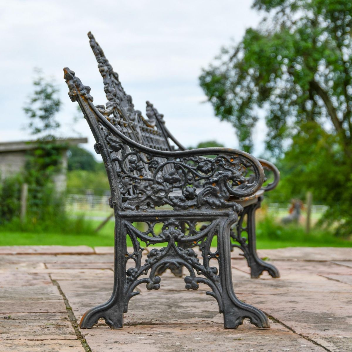 Side view of Aged Black Cast Iron Gothic Three Seater Bench and Decorative Legs Side view of Aged Black Cast Iron Gothic Three Seater Bench and Decorative Legs
