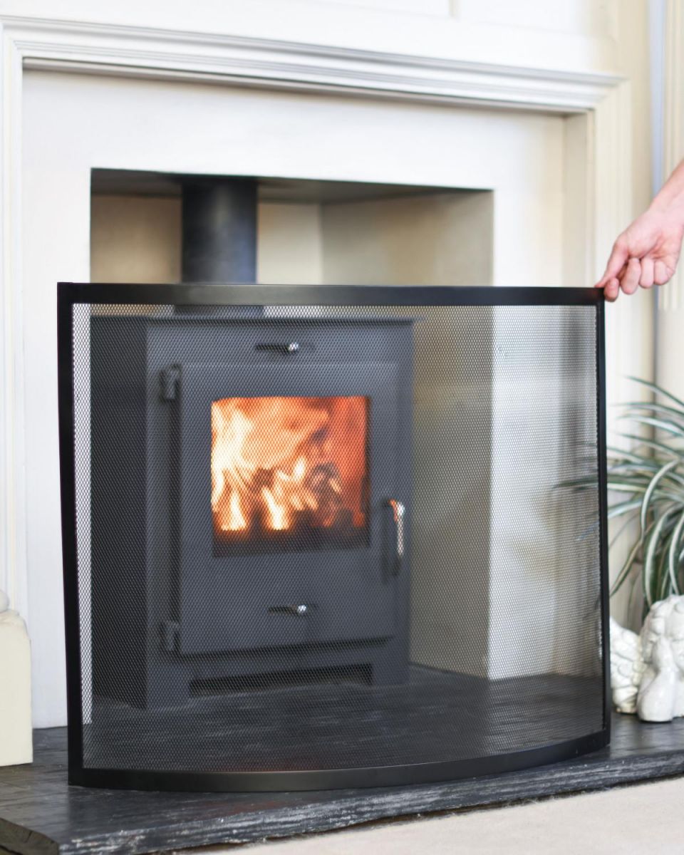 Scale Shot Of Black Contemporary Curved Single Panel Fire Guard In A Fireside Setting