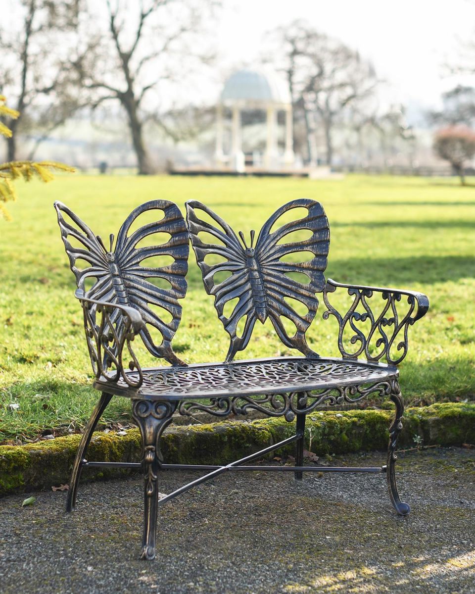 Butterfly Design Two Seater Bench in an Antique Gold Finish in Situ in the Garden
