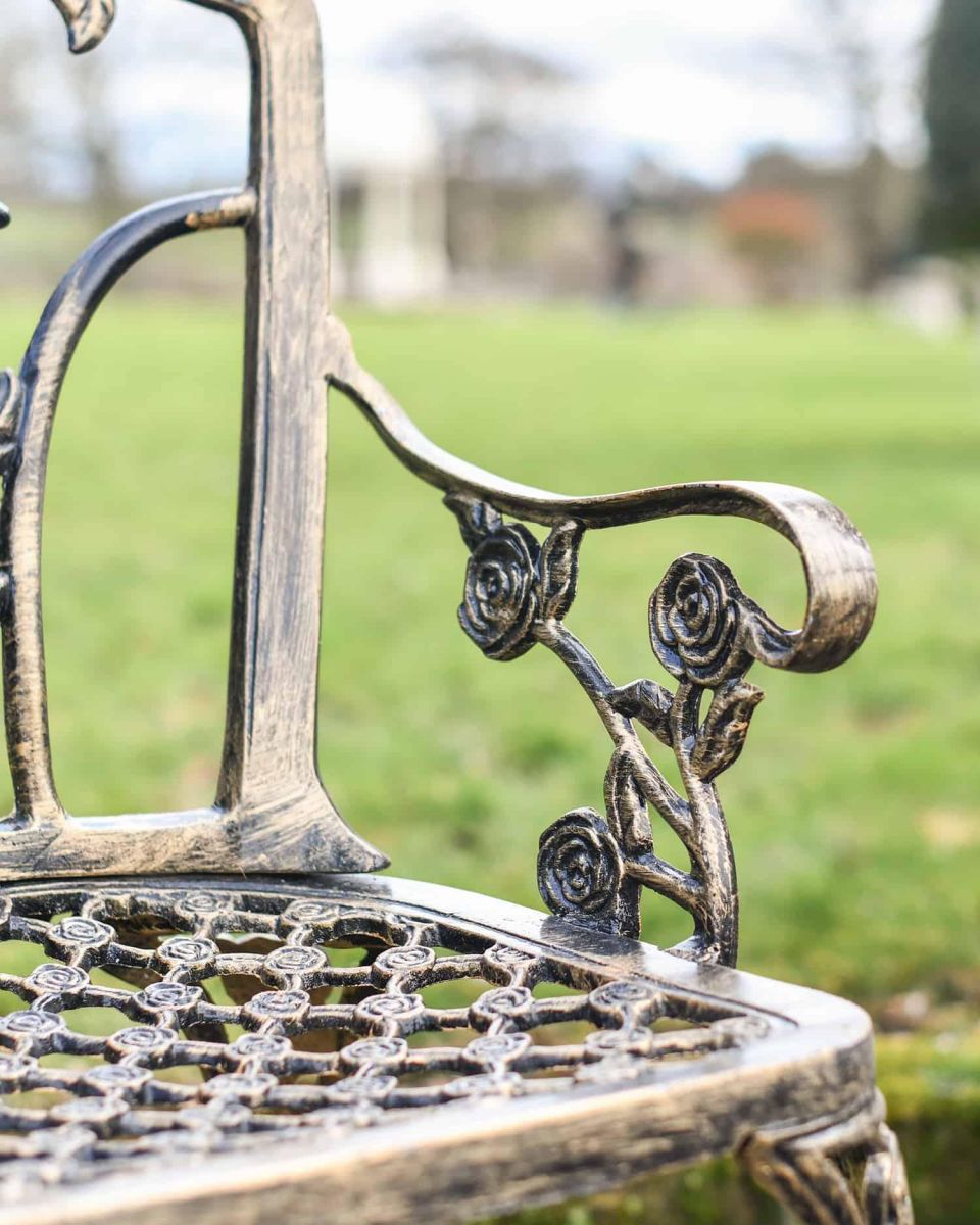 Close-Up of Ornate Armrests on Black & Gold Rose Design Bench