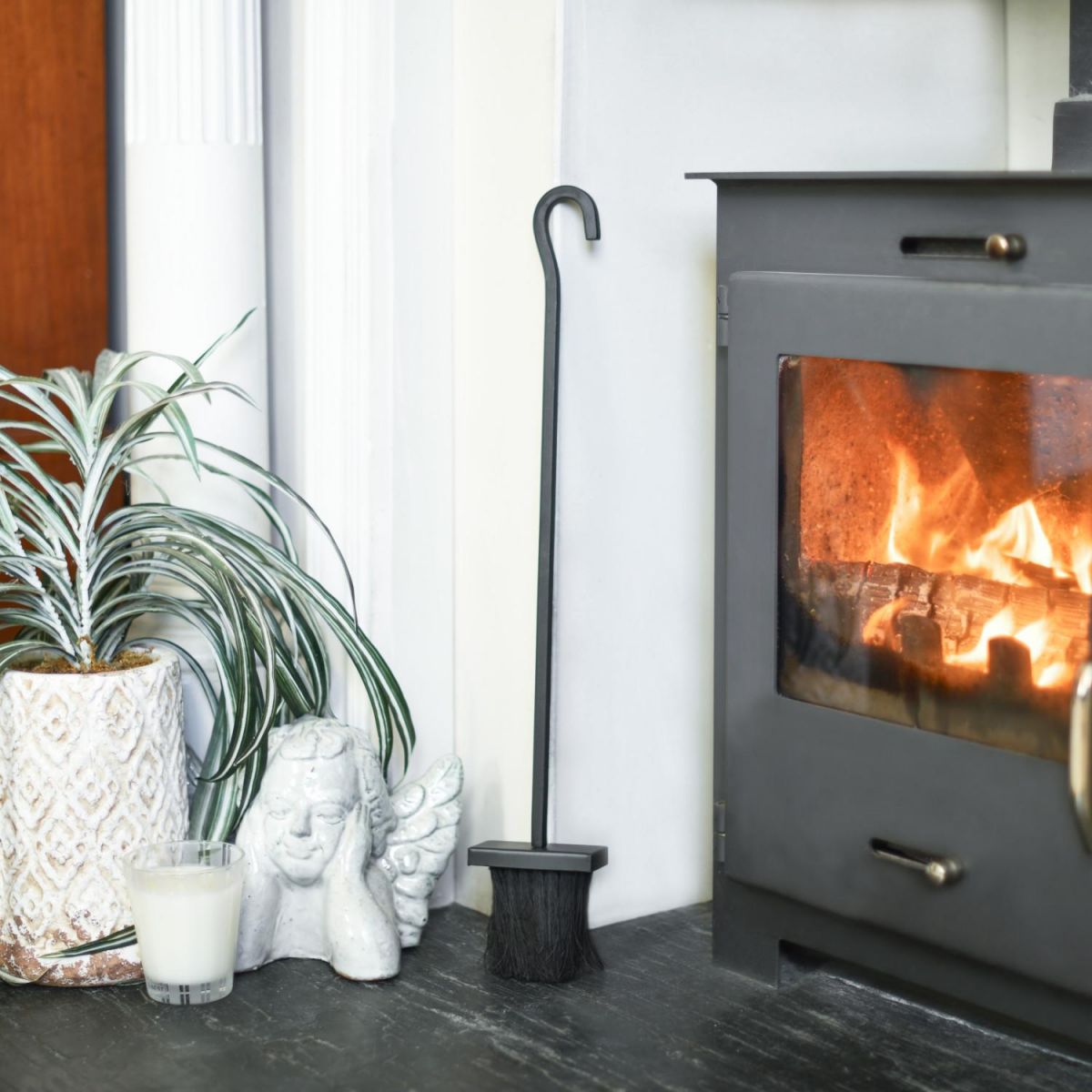 Black Hooked Fireside Brush In A Fireside Setting