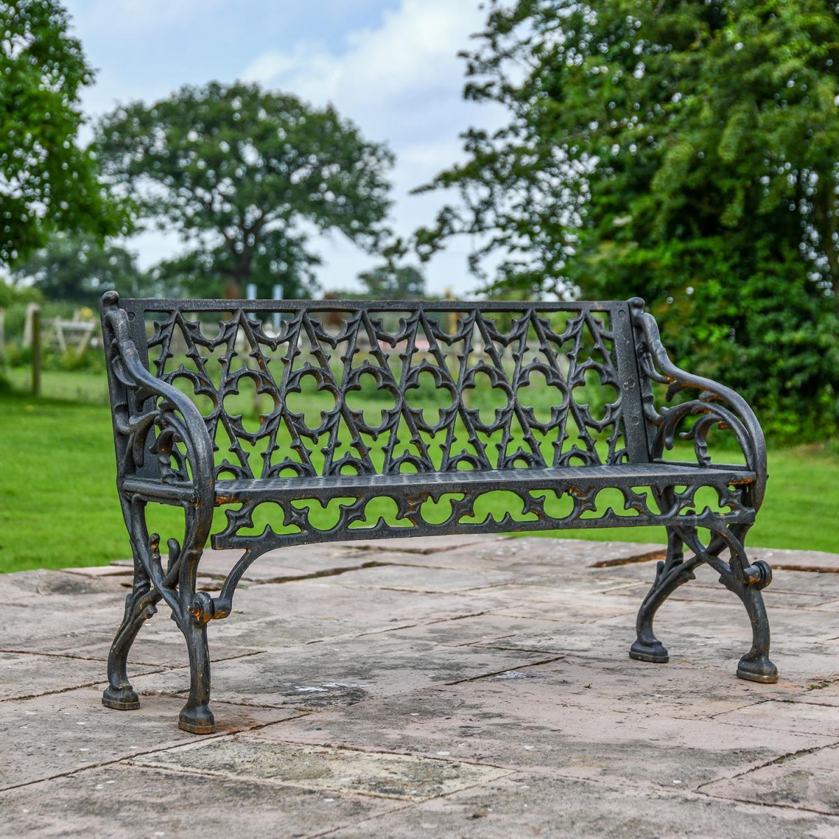 Aged Black "Quatrefoil" Victorian Cast Iron Two Seat Bench in Use on the Garden Patio Aged Black "Quatrefoil" Victorian Cast Iron Two Seat Bench in Use on the Garden Patio