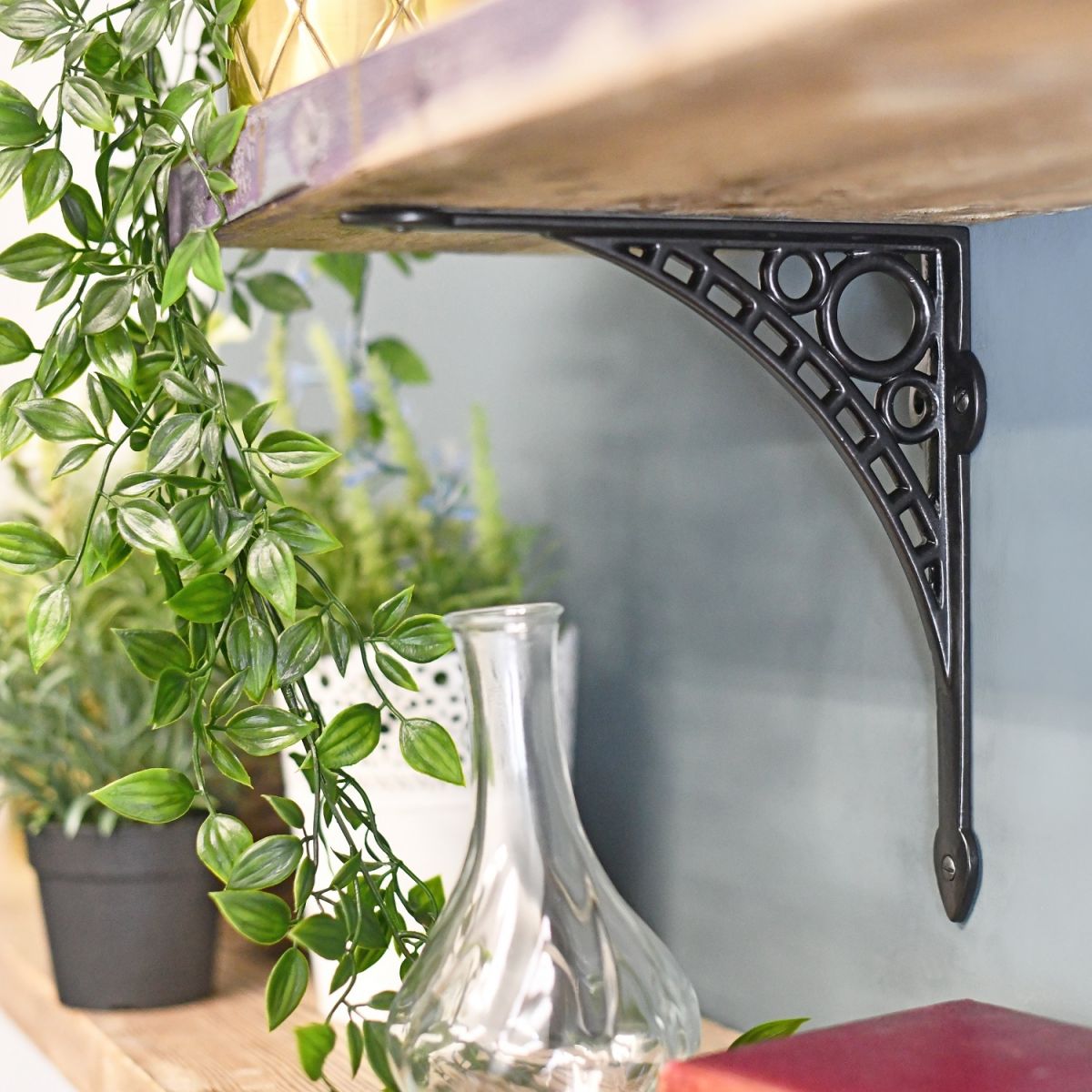 Black Iron Wall Bracket Holding Up Wooden Shelf