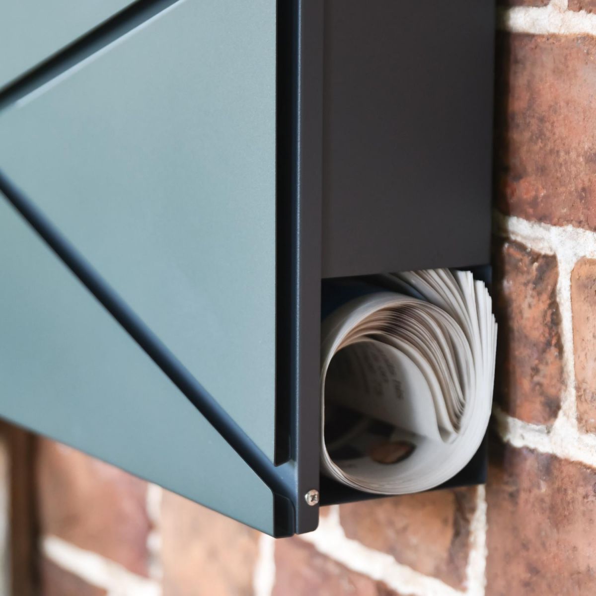 Close-Up of Newspaper Holder on Wall Mounted Post box