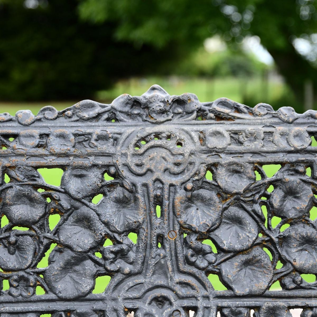 Close up of Aged Black Cast Iron Garden Bench Leaf Design on Backrest Close up of Aged Black Cast Iron Garden Bench Leaf Design on Backrest