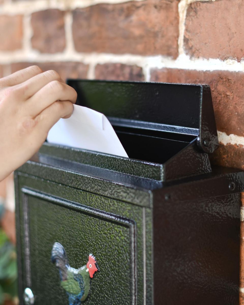 Letter Flap in Use on Black "Oxford" Rooster Wall Mounted Post Box with White Text