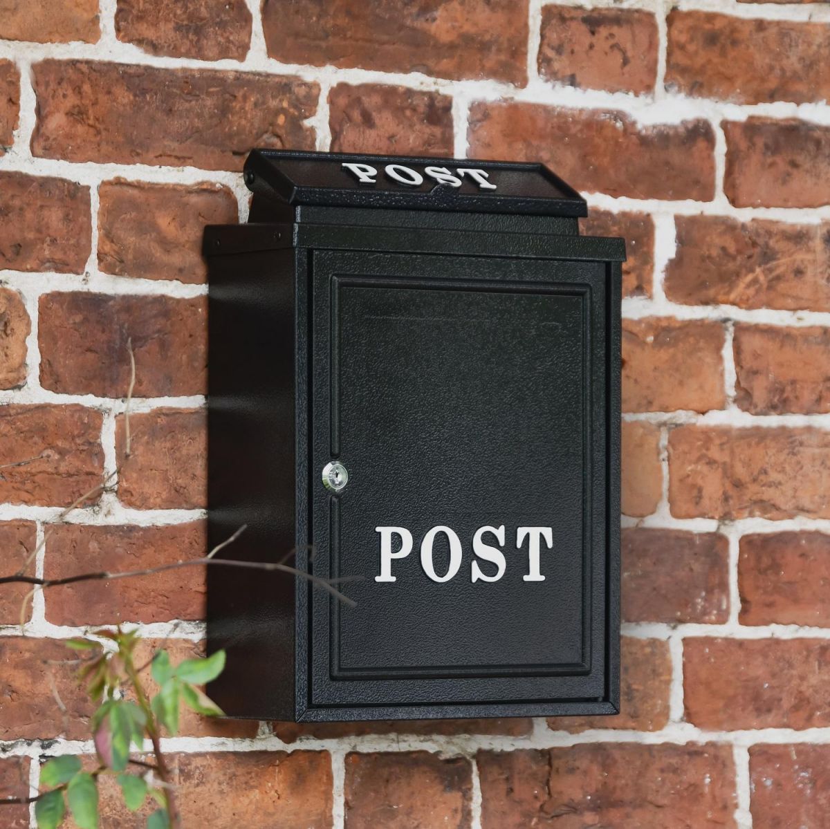 Black "Oxford" Wall Mounted Post Box with White Text in situ on a Brick Wall