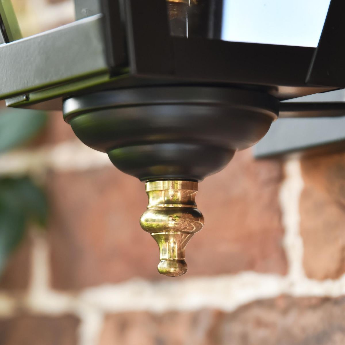 Close-Up of Polished Brass Finial on Black Wall Light