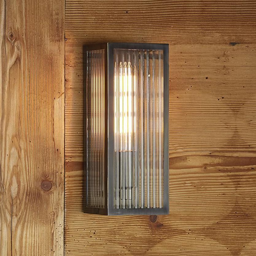 Rubbed Bronze Reeded Glass Wall Light in Situ on a Wooden Wall