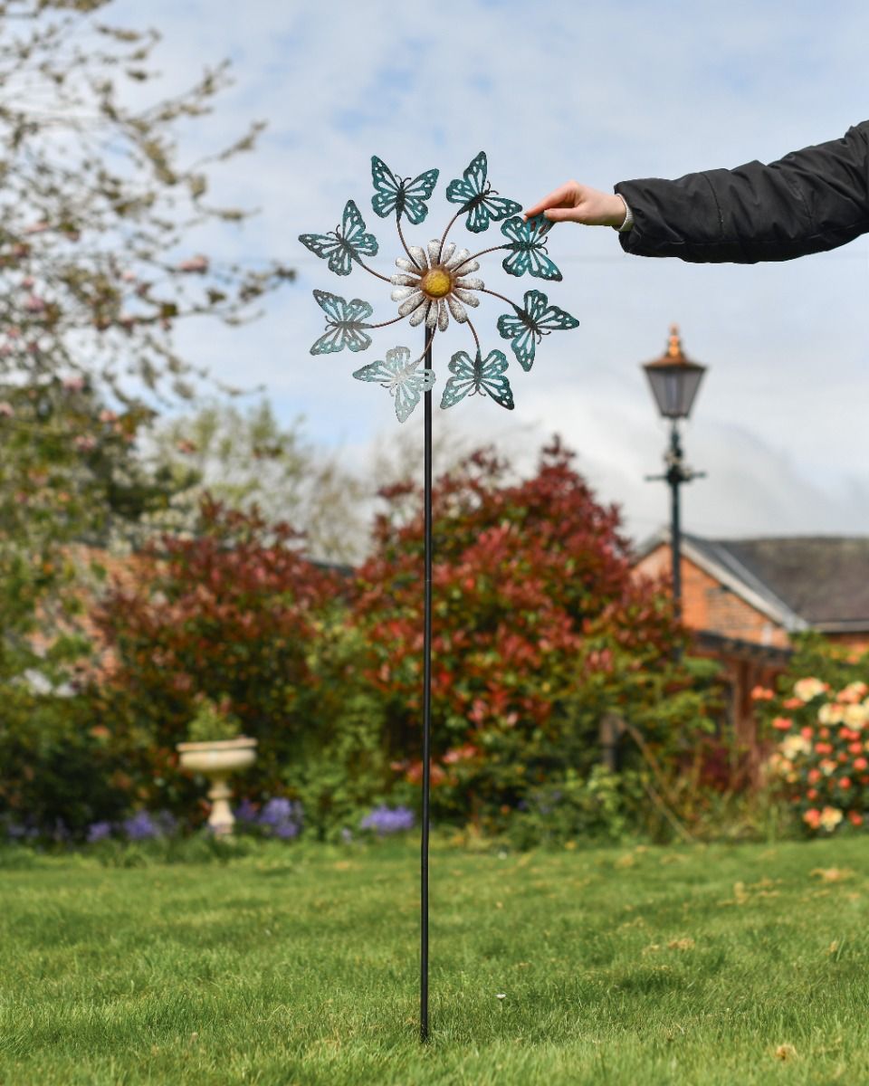Blue Butterfly and Daisy Flower Garden Spinner with Hand for Scale