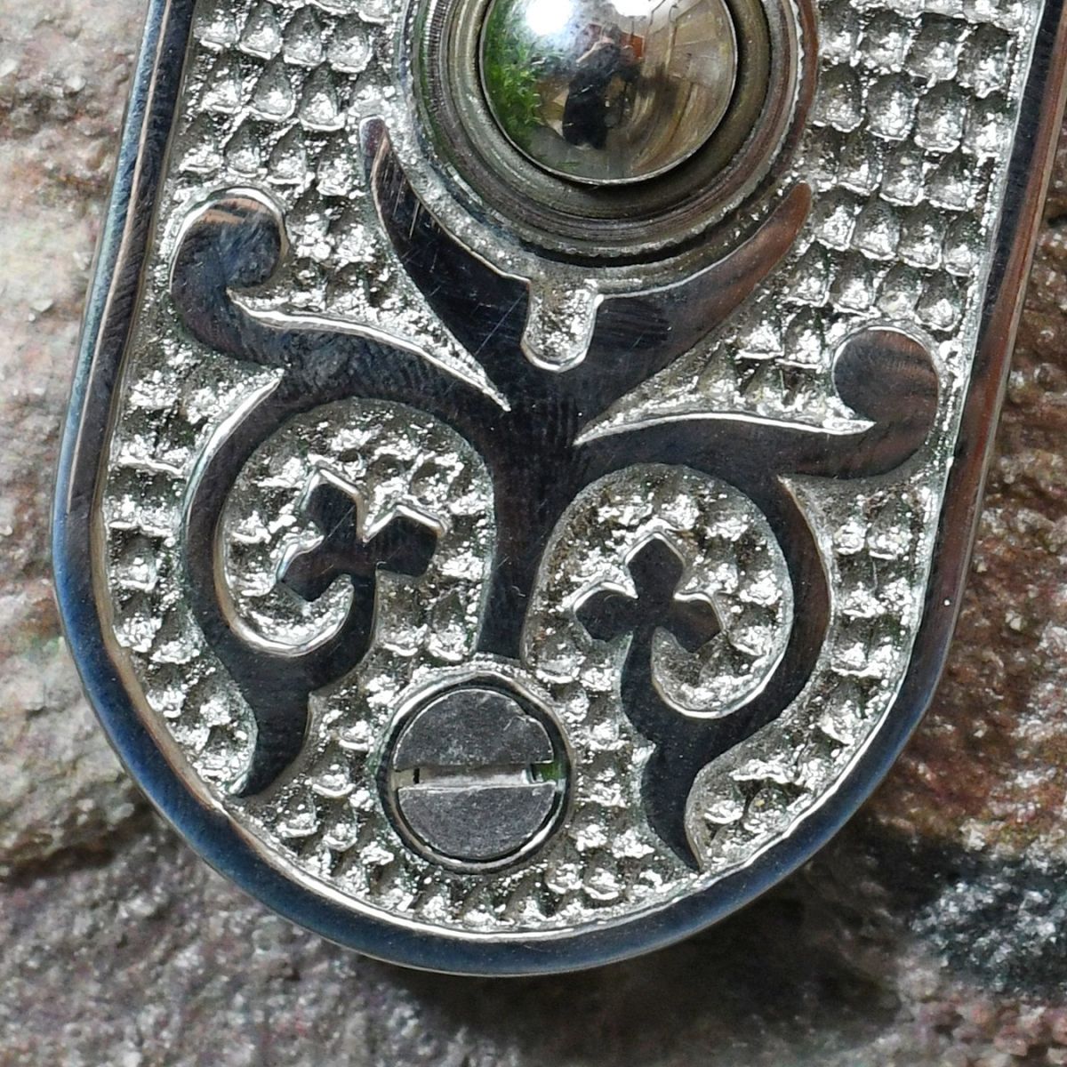 Close up of ornate pattern on door push button