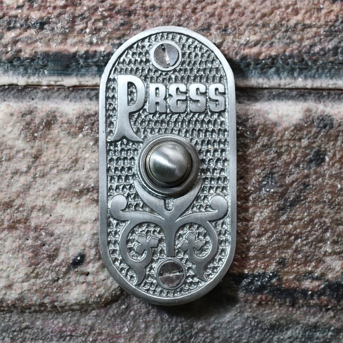 Old fashioned front door bell push on brick wall