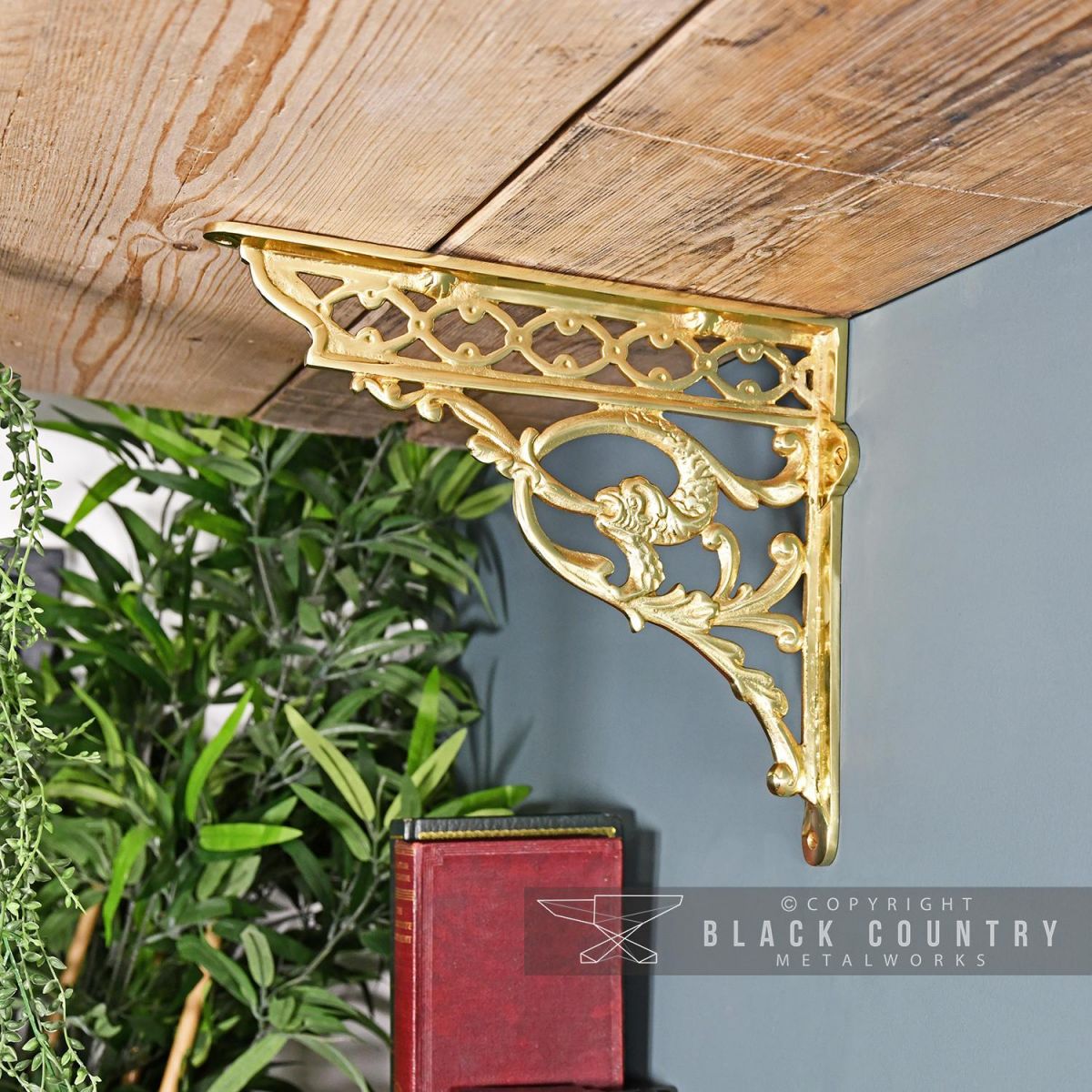 Brass Serpent Design Shelf Bracket in Situ Holding Up a Wooden Shelf 