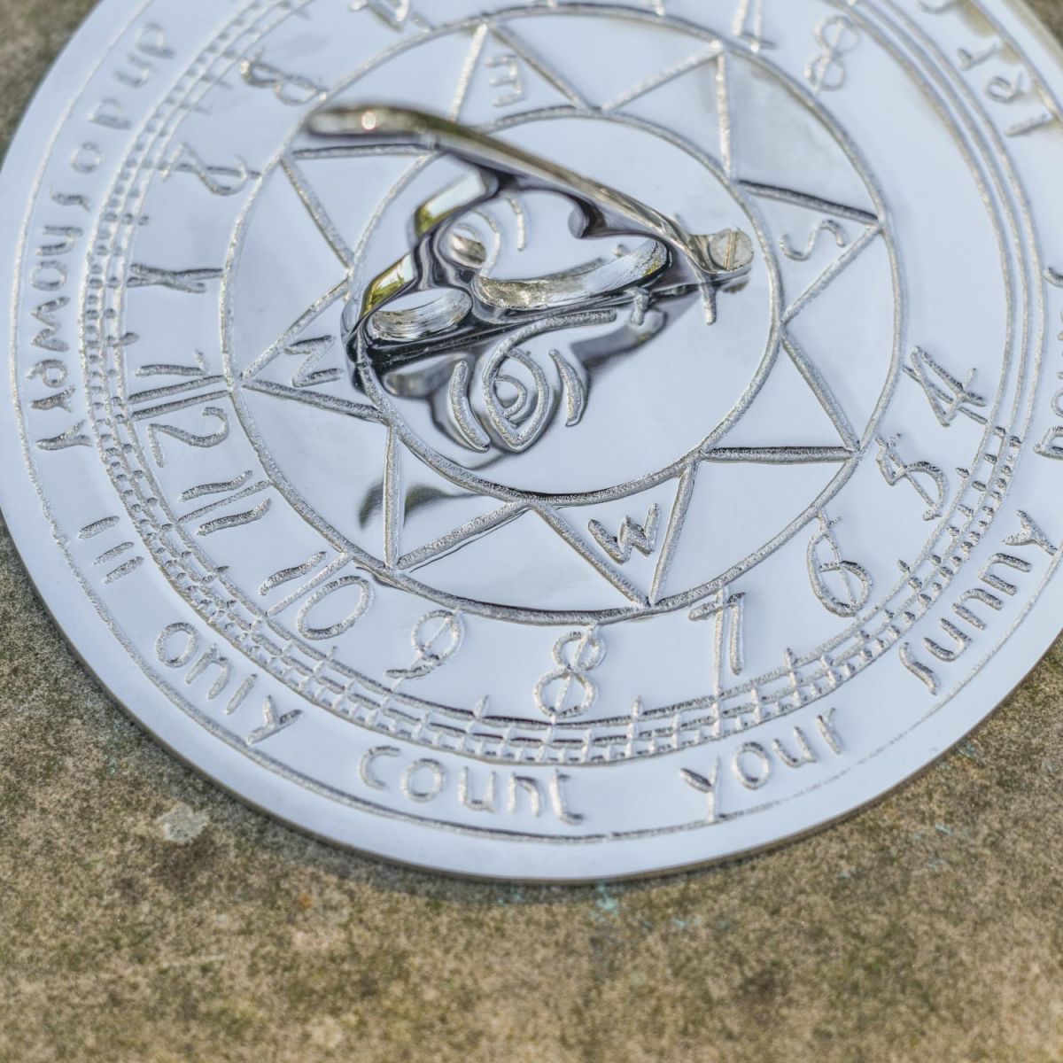 Close-Up of Bright Chrome Compass Point Sundial in Situ