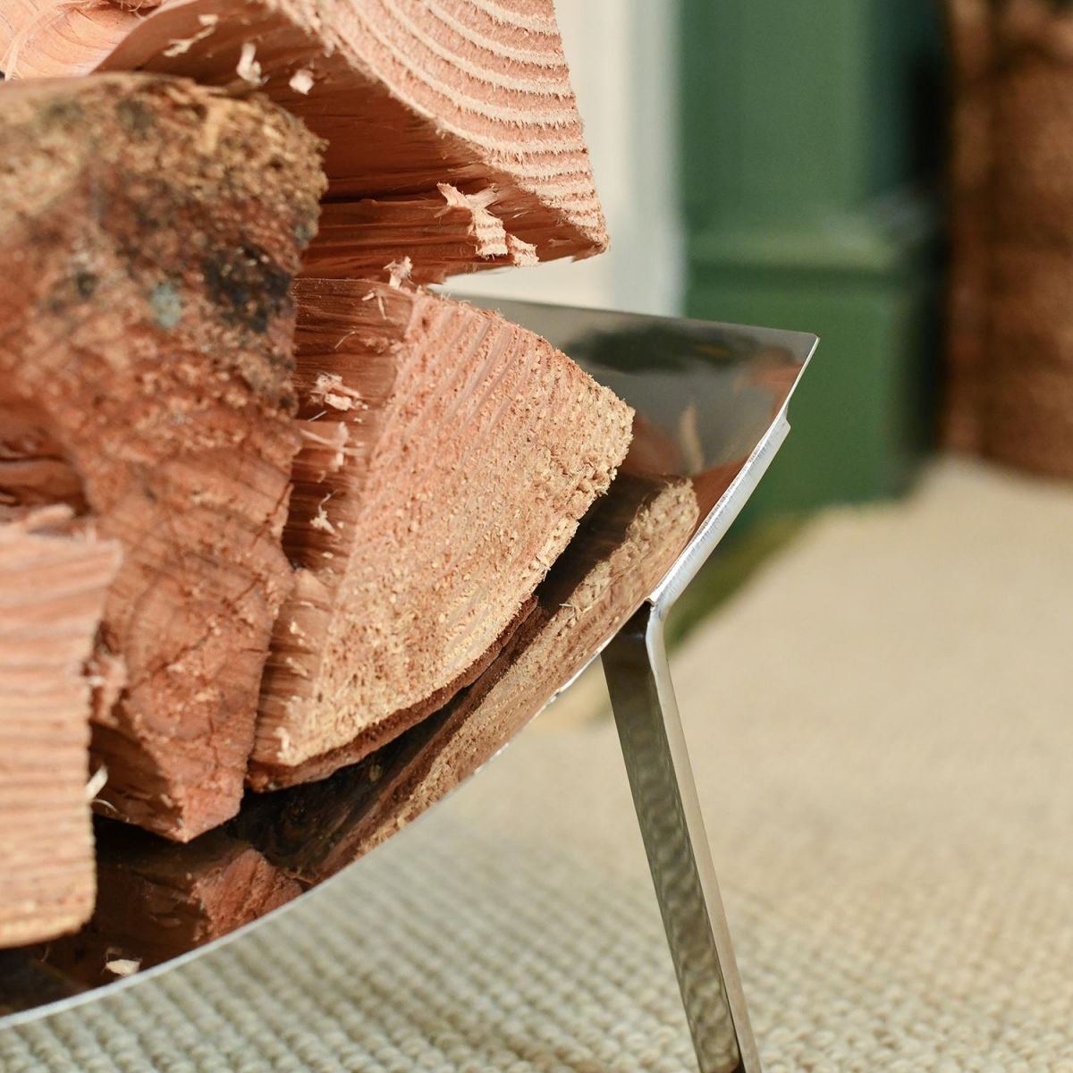 Close-up of the Bright Chrome Curved Contemporary Log Holder Holding Logs Close-up of the Bright Chrome Curved Contemporary Log Holder Holding Logs