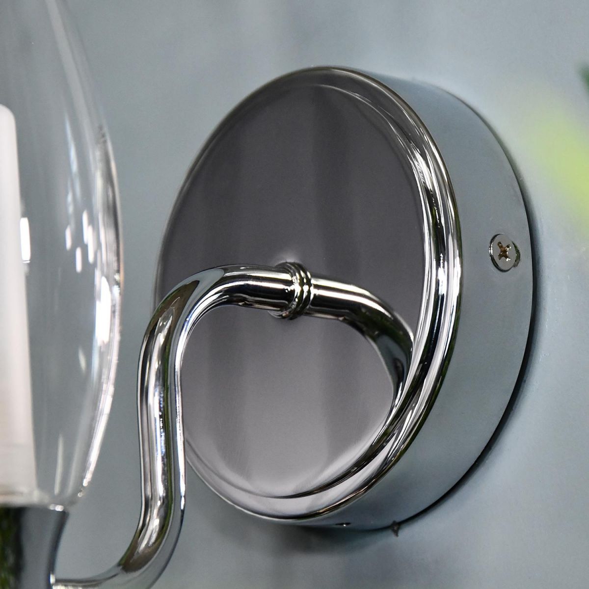 Close-up of the Bright Chrome Back Plate Mounted to a Blue Wall Close-up of the Bright Chrome Back Plate Mounted to a Blue Wall