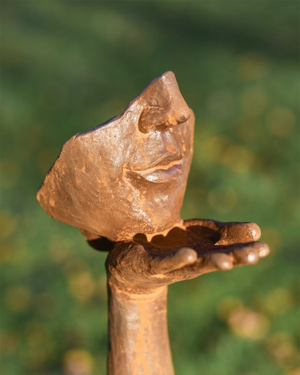 Close Up Of Rustic Cast Iron Blowing a Kiss Garden Sculpture