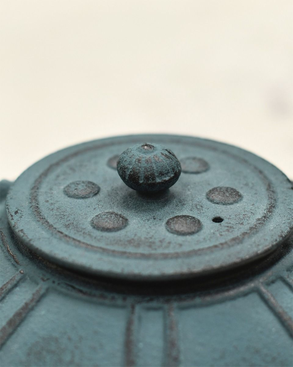 Close up of Teal Cast Iron Lid on Teapot