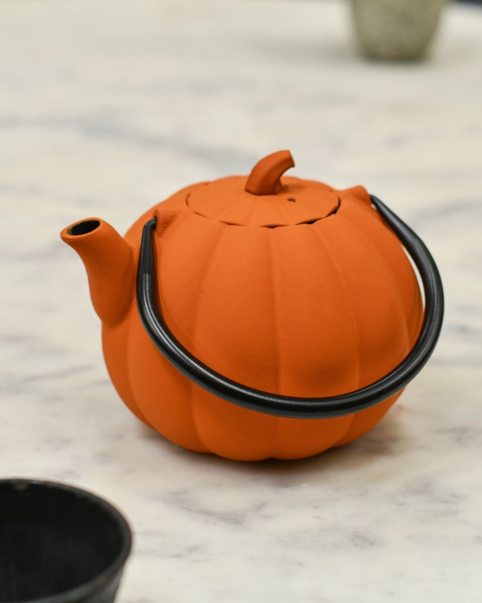 Moveable handle detail on orange teapot Moveable handle detail on orange teapot